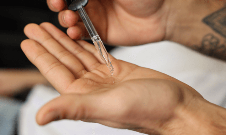man-dripping-beard-growth-oil-into-hand