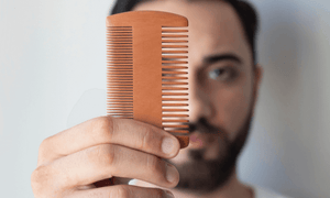 man-holding-beard-comb